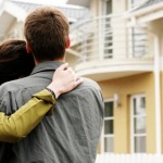couple in front of one-family house in modern residential area